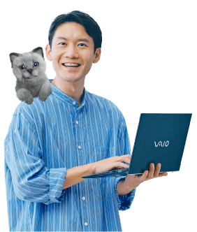 写真：猫を肩に乗せ、ノートパソコンを開き笑顔でこちらを見る男性